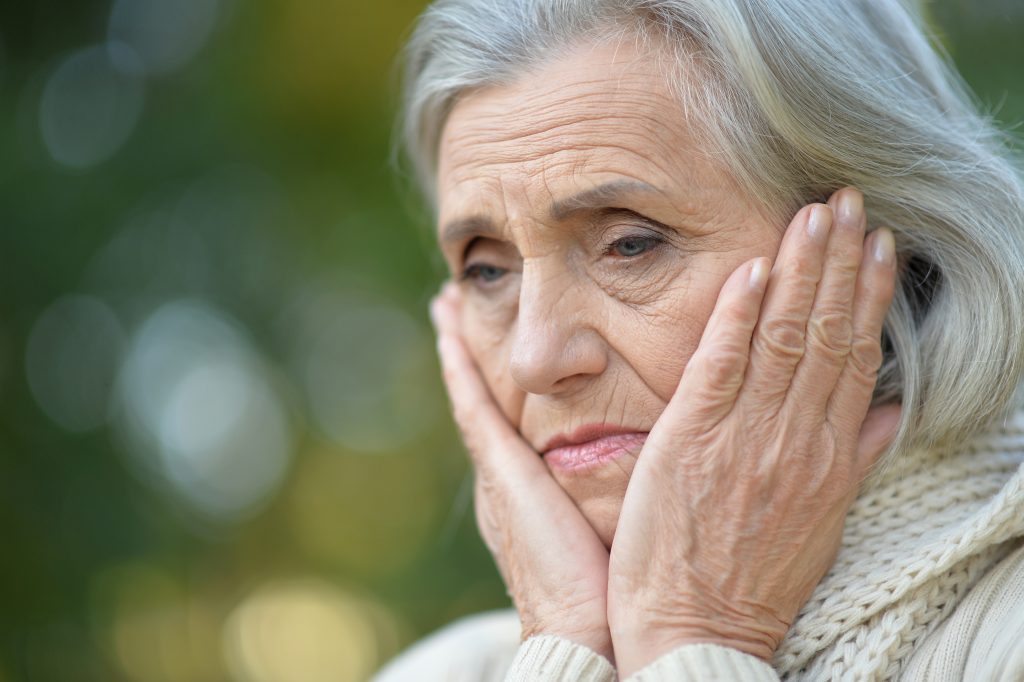 woman outside with hands on face looking discouraged. How to Believe God is Working When You Can't Hear Him