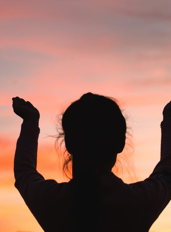 woman praising God at sunset. One of the Benefits of Faith is the Presence of God